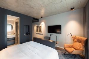 a bedroom with a bed and a chair at Legend Hotel in Cologne