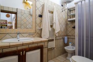 a bathroom with a sink and a toilet and a mirror at Casa vacanza Il Giglio in Manduria