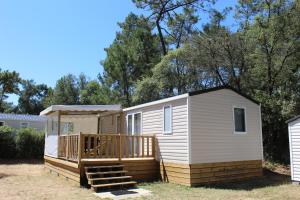 a tiny house with a porch and a deck at Le Domaine des Pins in Saint-Hilaire-de-Riez