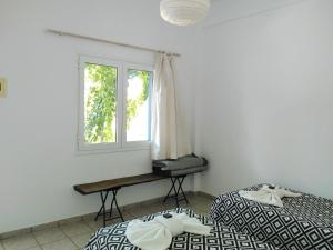 a bedroom with two beds and a window at Nissos Ios in Mylopotas