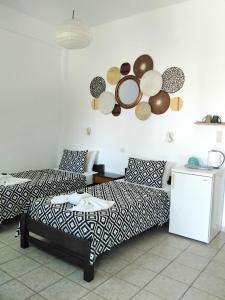una sala de estar con una cama y platos en la pared en Nissos Ios en Mylopotas