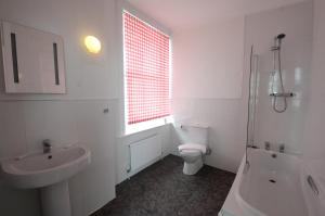 a white bathroom with a toilet and a sink at West Rocks Townhouse in Eastbourne