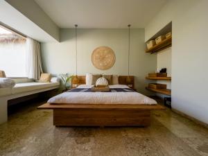 a bedroom with a large bed and a couch at Kai Villas Lombok in Kuta Lombok