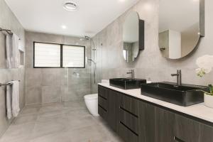 un bagno con due lavandini e uno specchio di Grandview Villa Kingscliff - Oceanview Tri-level Villa by uHoliday a Kingscliff Altre 17 foto