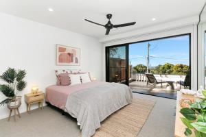 a bedroom with a bed and a large window at Grandview Villa Kingscliff - Oceanview Tri-level Villa by uHoliday in Kingscliff