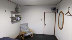豐中的住宿－roundabout TOYONAKA，一间房间,配有椅子和一扇带时钟的门