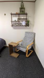 a living room with a chair and a table at roundabout TOYONAKA in Toyonaka