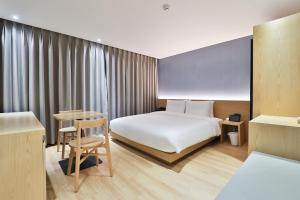 pokój hotelowy z łóżkiem i stołem w obiekcie Custom Hotel w mieście Ulsan