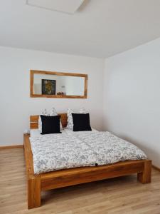 - une chambre avec un lit en bois et un miroir dans l'établissement Relax, à Bad Wildbad
