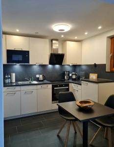 a kitchen with white cabinets and a table with chairs at Relax in Bad Wildbad