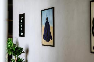 a picture of a woman in a blue dress hanging on a wall at Hotel Septembar in Podgorica