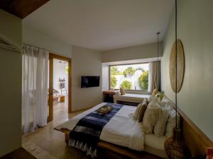 a bedroom with a large bed with a window at Kai Villas Lombok in Kuta Lombok