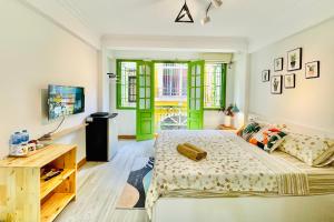 a bedroom with green doors and a bed at Vitamin Home Hoàn Kiếm 35 in Hanoi