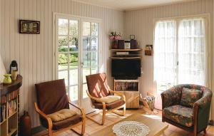 salon z 2 krzesłami i telewizorem w obiekcie 2 Bedroom Lovely Home In Dimont w mieście Dimont
