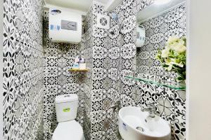 a bathroom with a white toilet and a sink at Vitamin Home Hoàn Kiếm 35 in Hanoi +69 photos