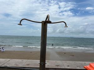a pole on the beach with people in the water at Homestay coco in Vung Tau