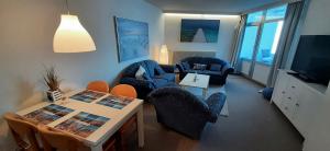 uma sala de estar com cadeiras, uma mesa e uma televisão em Haus des Kurgastes Haus des Kurgastes 1 em Heiligenhafen