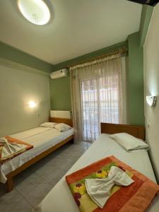 a bedroom with two beds and a window at Vangelis in Nea Vrasna +54 photos