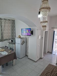 a kitchen with a refrigerator and a tv on the wall at Casa di nonna Anna in Lipari