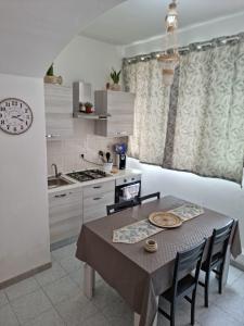 a kitchen with a table and chairs and a kitchen with a stove at Casa di nonna Anna in Lipari