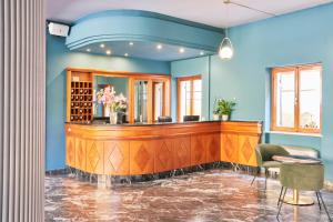 een bar in een kamer met blauwe muren bij Hotel Astoria in Garda