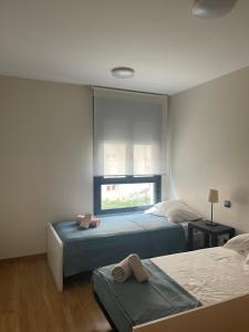 sypialnia z dwoma łóżkami i oknem w obiekcie GES Homes w mieście Almería