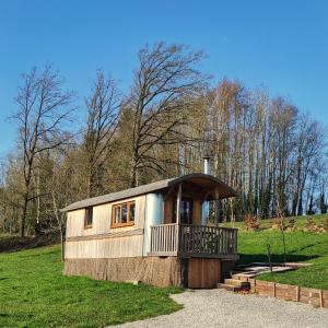 ein kleines Haus mit Balkon auf einem Feld in der Unterkunft La RouLodge du Veilleur - Hôtel Insolite in Ermeton-sur-Biert