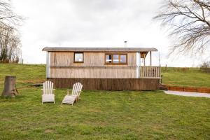 two chairs in front of a tiny house at La RouLodge du Veilleur - Hôtel Insolite in Ermeton-sur-Biert