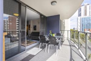 een balkon met een tafel en stoelen en een bank bij 24 Amazing Adelaide Tce 2br 2ba Location in Perth