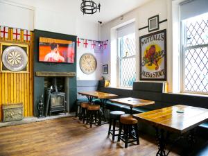 un restaurante con mesas, chimenea y reloj en OYO Castle Hotel, Accrington en Accrington