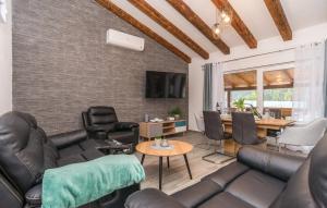 a living room with leather furniture and a dining room at Villas Pakoštane in Pakoštane
