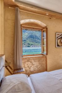 a bedroom with a window with a view of the ocean at Stone Home Kotor in Dobrota