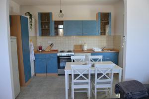 a kitchen with blue cabinets and a table and chairs at Cherry in Korčula