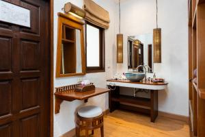 a bathroom with a sink and a mirror at The Legend Chiang Rai Boutique River Resort & Spa - SHA Extra Plus in Chiang Rai