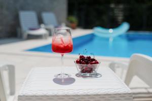 a drink in a glass on a table with a bowl of cherries at Villa Old Town Stolac in Stolac +37 photos