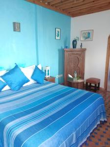 1 dormitorio azul con 1 cama grande y paredes azules en Riad Dar Zouhour en Rabat