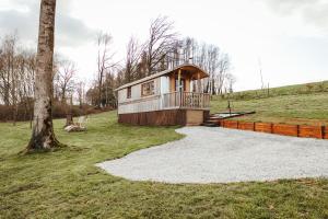 a tiny house on a hill with a tree at La RouLodge du Veilleur - Hôtel Insolite in Ermeton-sur-Biert
