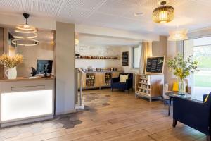 a restaurant with a counter and chairs in a room at BEST WESTERN La Porte des Châteaux in Meung-sur-Loire