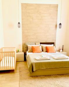 - une chambre dotée d'un lit avec des oreillers orange et un lit bébé dans l'établissement Casa Neva, à Trani