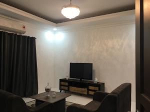 a living room with a flat screen tv on a wall at Fadi's Guesthouse at Bandar Baru Samariang in Kuching