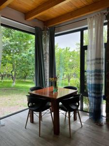 ein Esszimmer mit einem Tisch und Stühlen sowie großen Fenstern in der Unterkunft Green Stone Boutique Hotel in Yeghegnadzor