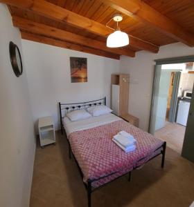 a bedroom with a bed with two towels on it at G-George Apartments by the Sea and Airport in Liádha