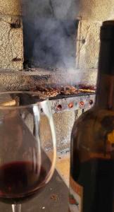 a glass of wine next to a grill with smoke at Alojamiento Pena da Osa in Sober +29 photos