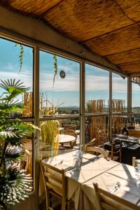 una sala da pranzo con tavolo e alcune finestre di Agriturismo Cerrosughero a Canino Altre 37 foto