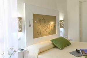 um quarto com uma cama com uma almofada verde em ALGHERO NOON em Alghero