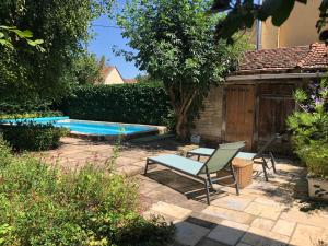 a patio with two chairs and a swimming pool at Le Séchoir du Ried in Rossfeld