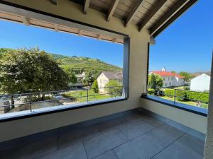 einen Balkon mit einem großen Fenster mit Aussicht in der Unterkunft Weingut & Straußwirtschaft Vogel in Vogtsburg