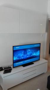 una TV a schermo piatto seduta su un centro di intrattenimento bianco di Cosy house Stratoni Chalkidiki 300m from beach a Stratoni