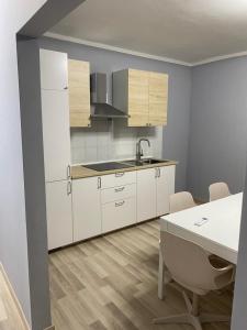 a kitchen with white cabinets and a table with chairs at VISTAMARE VILLAGE in Silvi Marina