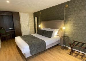 Cette chambre comprend un grand lit et un bureau. dans l'établissement Hotel De Guise Nancy Vieille Ville, à Nancy